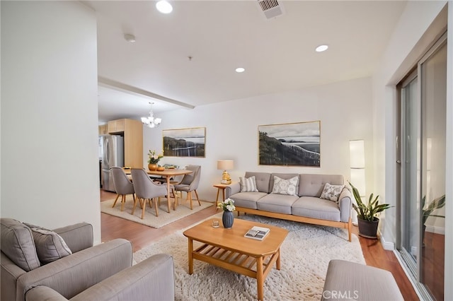 living room featuring a chandelier and light wood-type flooring