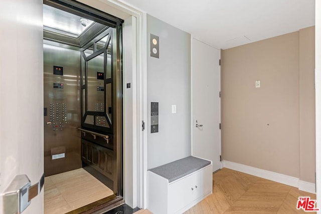 interior space featuring elevator and light parquet flooring