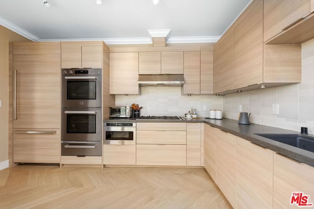 kitchen with ornamental molding, light parquet floors, light brown cabinetry, and appliances with stainless steel finishes