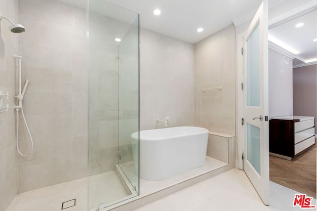 bathroom featuring tile patterned flooring and shower with separate bathtub