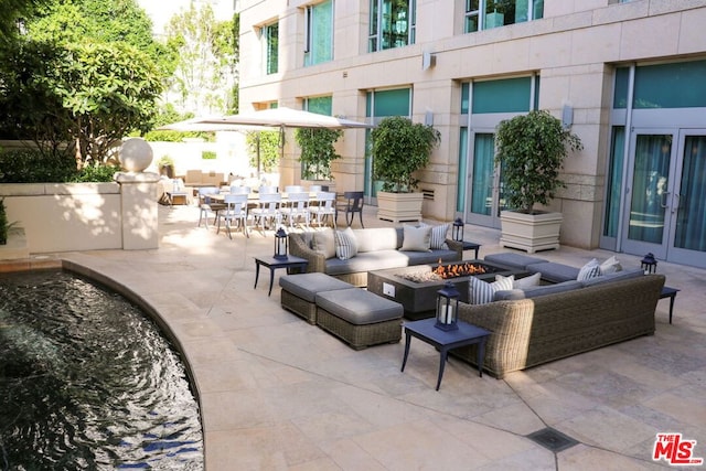 view of patio with french doors and an outdoor living space with a fire pit