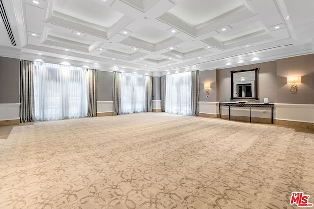 carpeted empty room featuring coffered ceiling and beamed ceiling