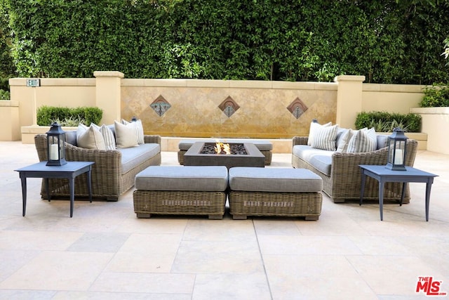 view of patio with an outdoor living space with a fire pit