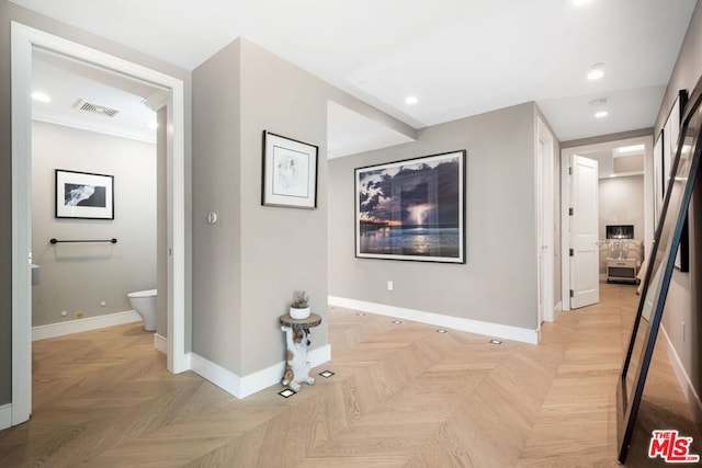 hallway featuring light parquet flooring and ornamental molding