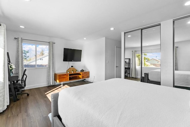 bedroom featuring dark hardwood / wood-style flooring and two closets