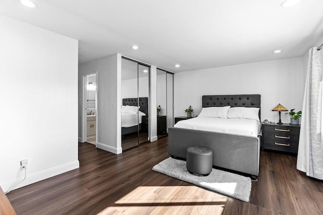 bedroom featuring multiple closets and dark wood-type flooring