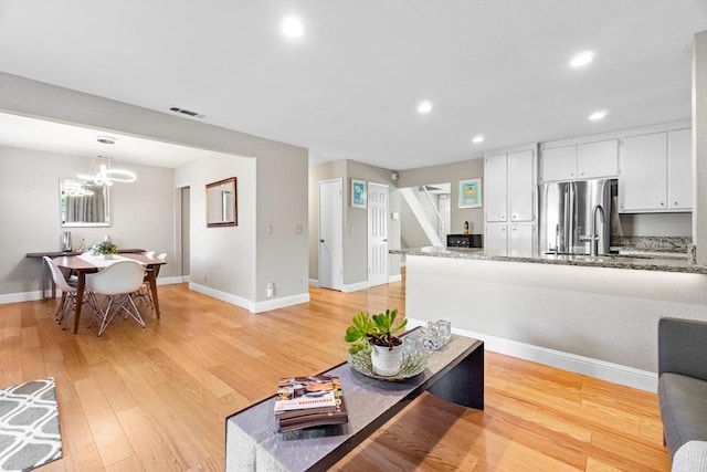 living room featuring a notable chandelier and light hardwood / wood-style floors