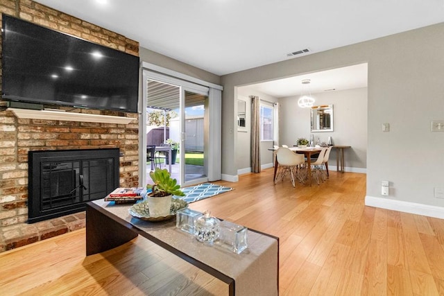 living room featuring hardwood / wood-style floors and a brick fireplace