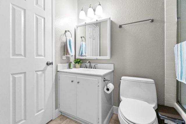 bathroom with walk in shower, vanity, and toilet