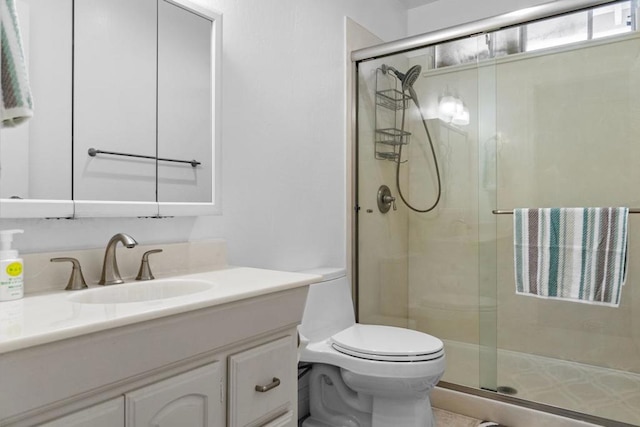 bathroom with vanity, toilet, and a shower with door