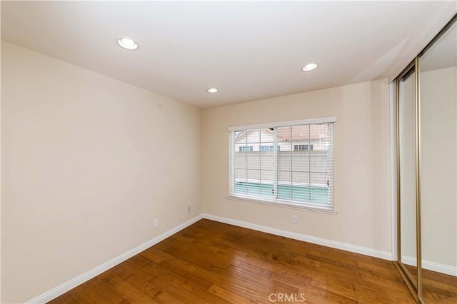 unfurnished room with hardwood / wood-style flooring