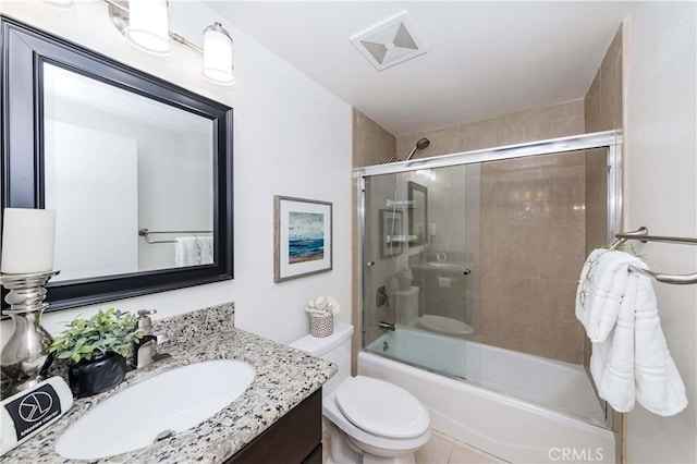 full bathroom with tile patterned floors, toilet, vanity, and shower / bath combination with glass door