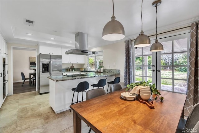 dining space featuring sink, a tray ceiling, ornamental molding, and french doors