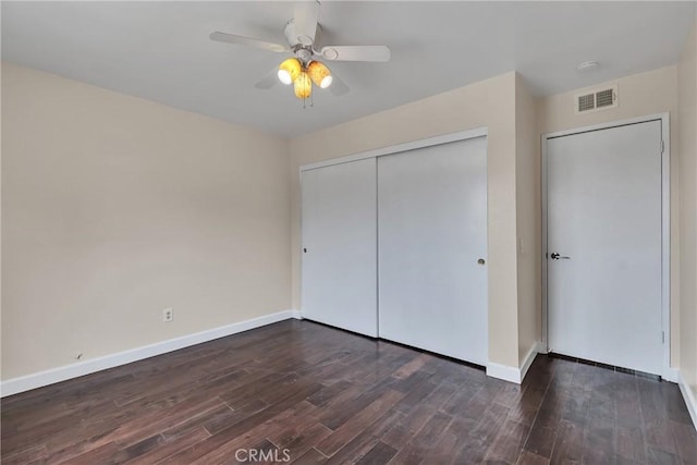 unfurnished bedroom with dark wood-type flooring, ceiling fan, and a closet