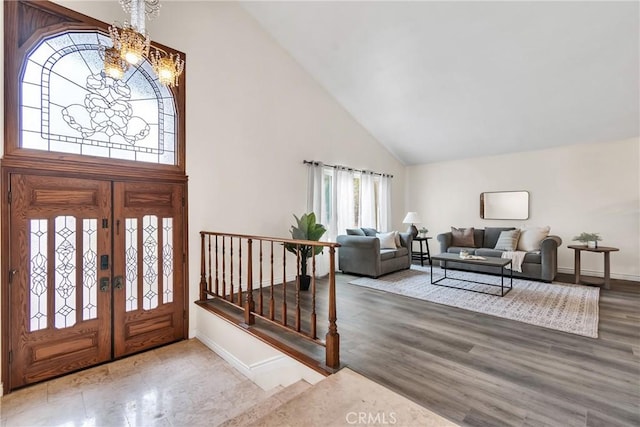 entryway featuring high vaulted ceiling, hardwood / wood-style floors, and a notable chandelier