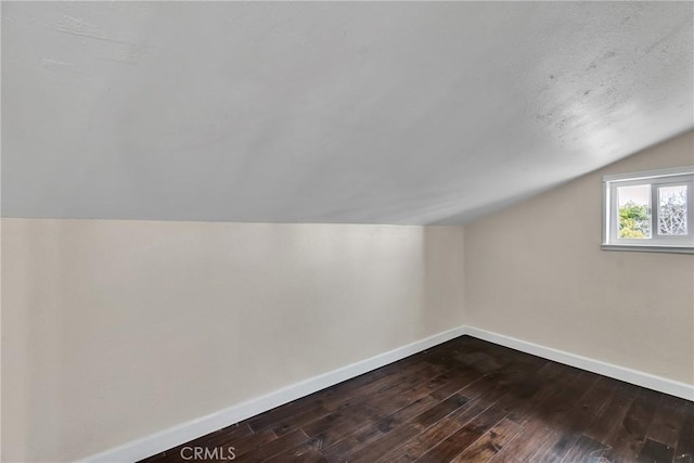 additional living space with hardwood / wood-style flooring and lofted ceiling