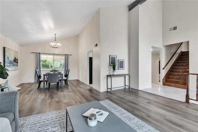 living room with hardwood / wood-style floors, high vaulted ceiling, and a chandelier