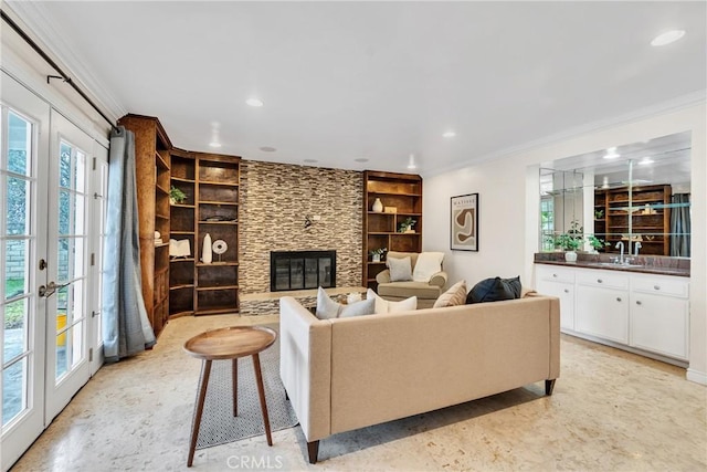 living room with crown molding, a fireplace, and built in shelves