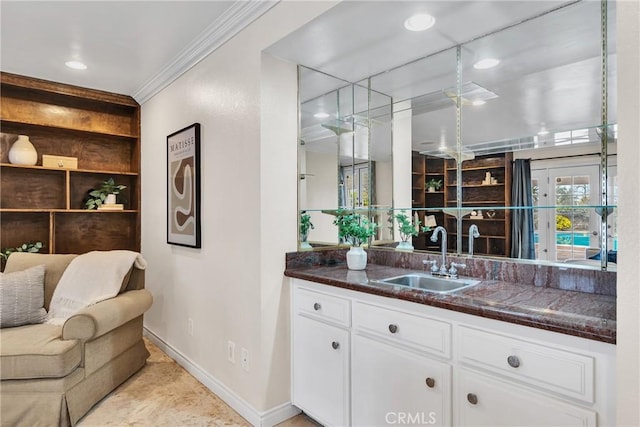 bar with sink, ornamental molding, and white cabinets