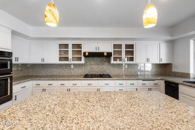 kitchen with black appliances, decorative backsplash, white cabinets, and decorative light fixtures