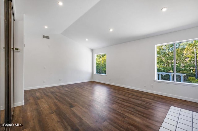 empty room featuring dark hardwood / wood-style floors and vaulted ceiling