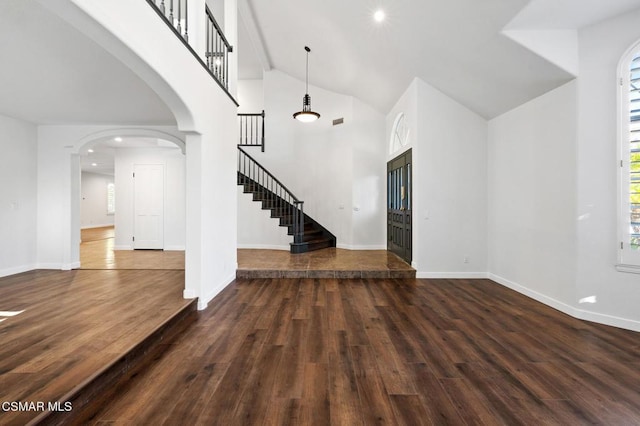 unfurnished living room featuring dark hardwood / wood-style floors and a high ceiling