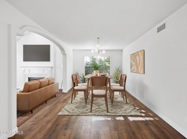 dining space featuring wood-type flooring and a chandelier