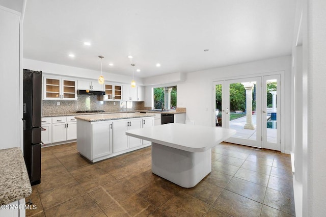 kitchen featuring white cabinetry, sink, hanging light fixtures, a center island, and black appliances