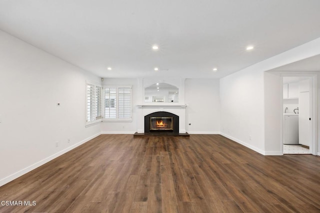 unfurnished living room with washer / clothes dryer and dark wood-type flooring