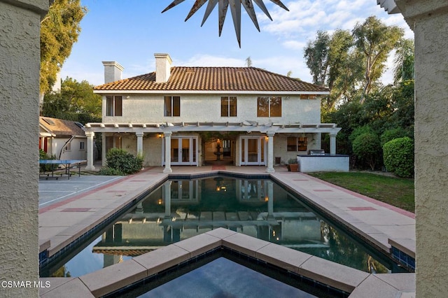 rear view of house with french doors, a pergola, and a patio