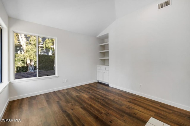 unfurnished room featuring lofted ceiling, built in features, and dark hardwood / wood-style floors