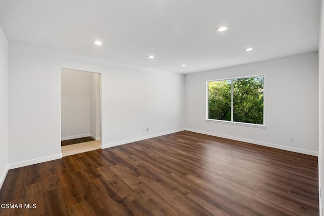 unfurnished room with dark wood-type flooring