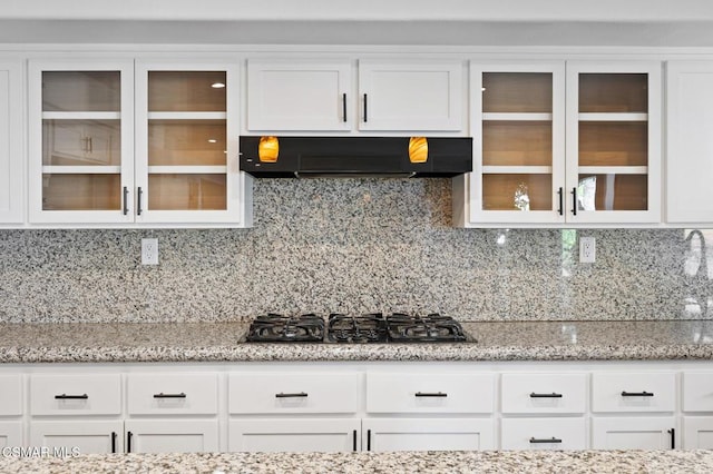 kitchen with white cabinetry, exhaust hood, and decorative backsplash