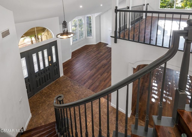 foyer entrance featuring dark hardwood / wood-style flooring, a wealth of natural light, and vaulted ceiling