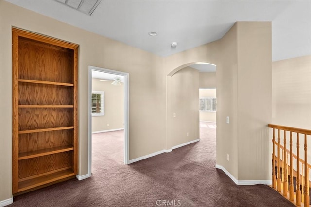 corridor featuring dark colored carpet