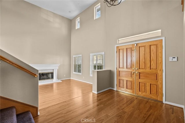 unfurnished living room featuring wood-type flooring and a high ceiling