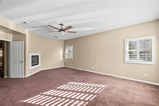 unfurnished living room featuring ceiling fan and carpet flooring