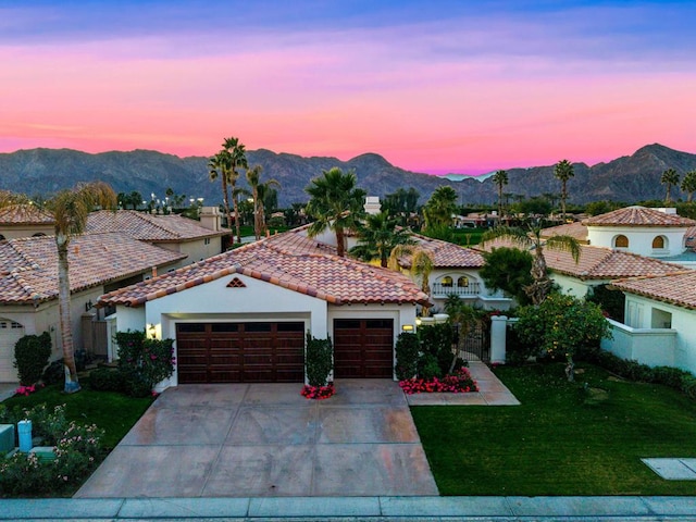 mediterranean / spanish house with a mountain view and a lawn