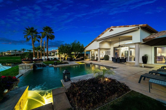 view of swimming pool with pool water feature, a patio, ceiling fan, and french doors