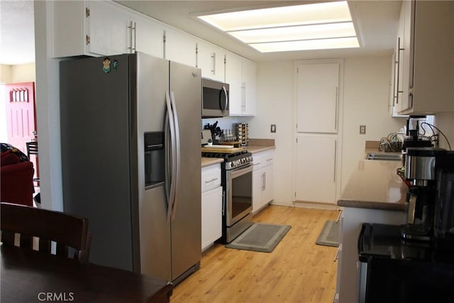 kitchen featuring sink, white cabinets, light hardwood / wood-style flooring, and stainless steel appliances