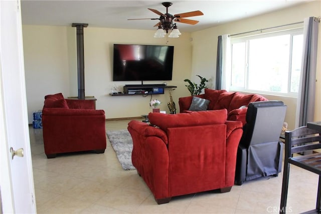 living room featuring a wood stove and ceiling fan