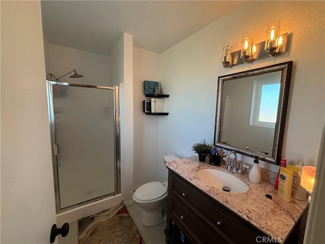 bathroom featuring toilet, a shower with shower door, and vanity