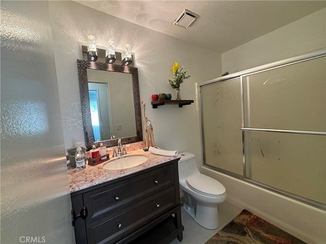 full bathroom with combined bath / shower with glass door, toilet, and vanity