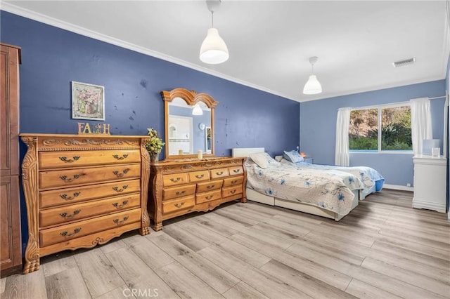 bedroom featuring ornamental molding and light hardwood / wood-style flooring