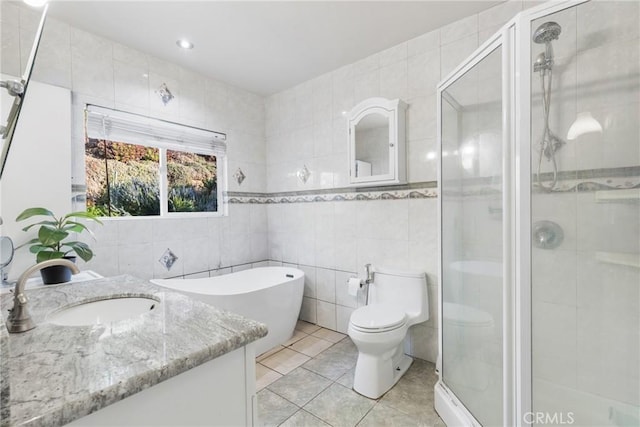 full bathroom with tile patterned floors, toilet, tile walls, vanity, and plus walk in shower