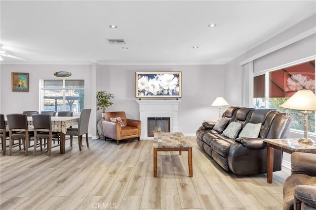 living room featuring ornamental molding, ceiling fan, and light hardwood / wood-style flooring