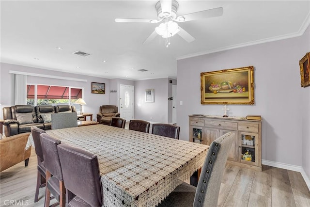 dining room featuring light hardwood / wood-style flooring, ornamental molding, and ceiling fan