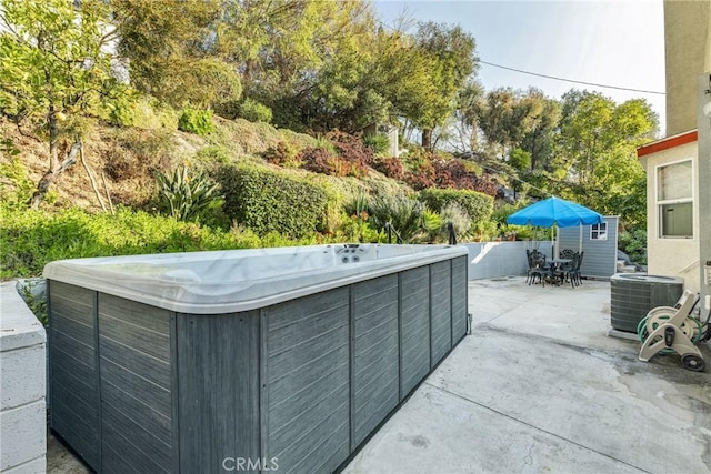 exterior space with a hot tub and central AC