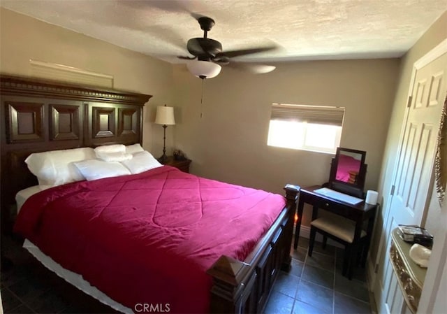 tiled bedroom featuring ceiling fan and a textured ceiling