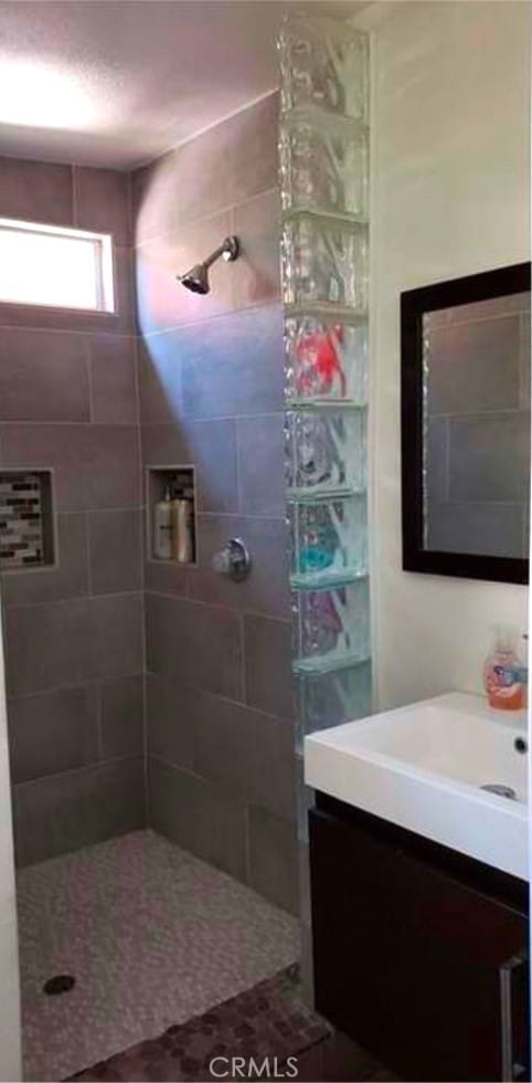 bathroom featuring vanity and a tile shower